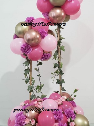 Decorated small and large ballloons 40 balloons shades of pink at bottom and flowers with shades of pink balloons cluster on top of 2 stick